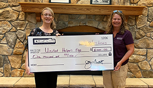 Two people holding a large Casella donation check.