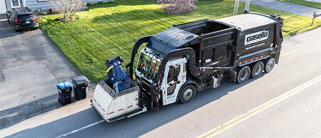 A Casella waste truck collecting recycling bin from home.