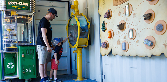 Father and child interacts with an educational exhibit at a Casella community event