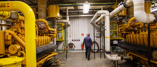 A Casella worker inspects machines monitoring GHG emissions.