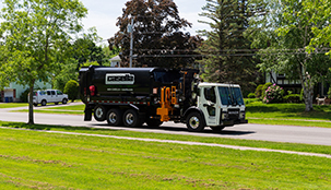 A Casella waste truck driving through a residential neighborhood