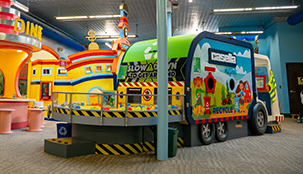 A indoor Casella play place for children with a giant toy garbage truck